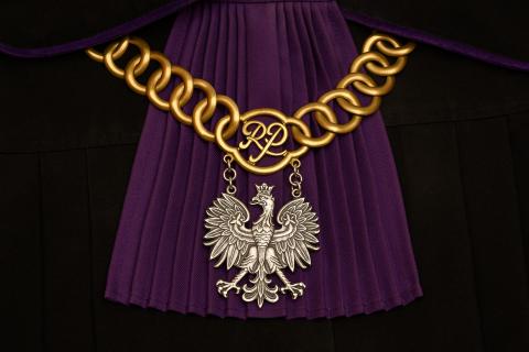Łańcuch sędziowski z orłem w koronie założony na togę z purpurowym żabotem